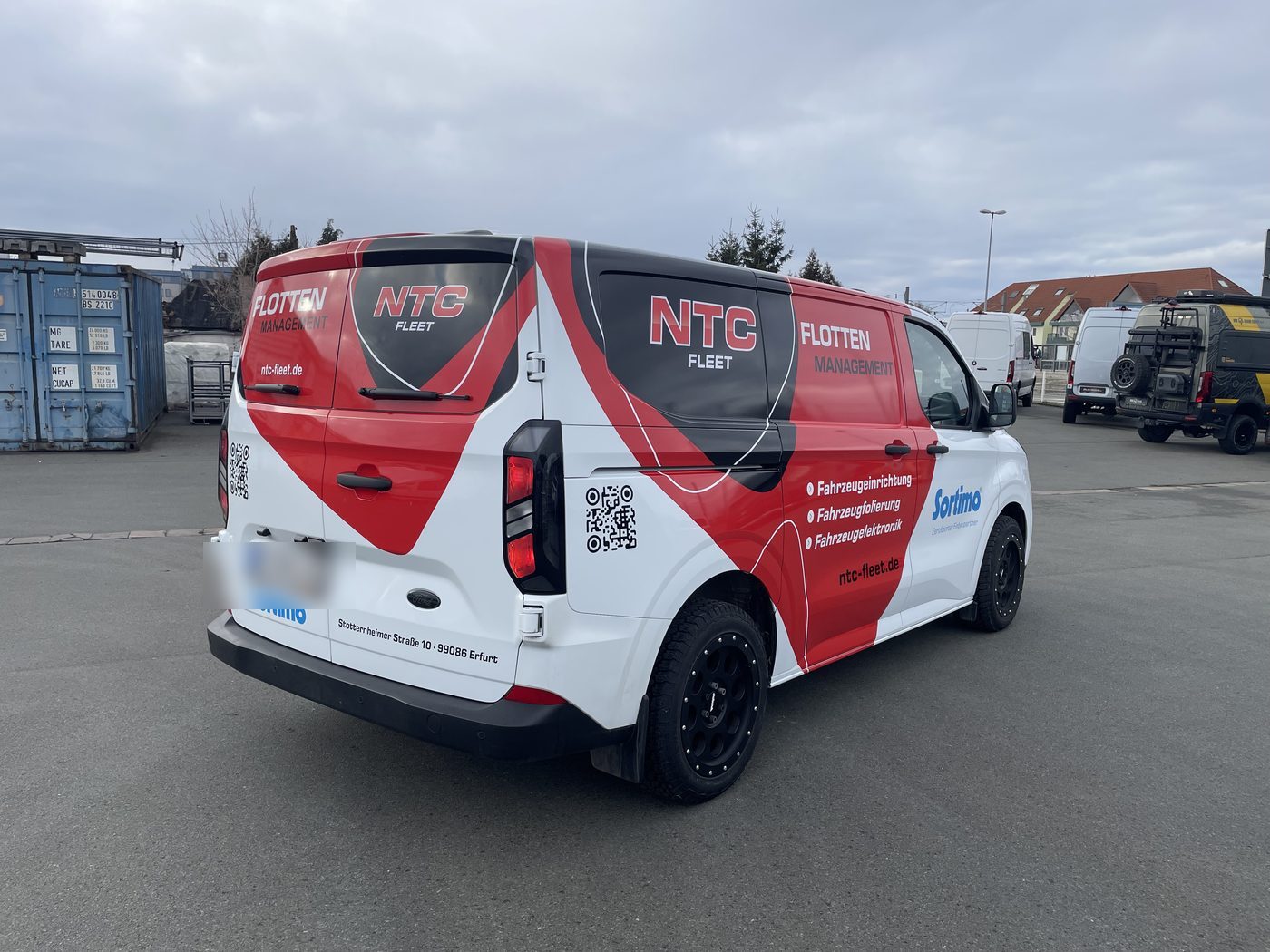 Beklebter Transporter von NTC Fleet in den Hausfarben Rot und Weiß